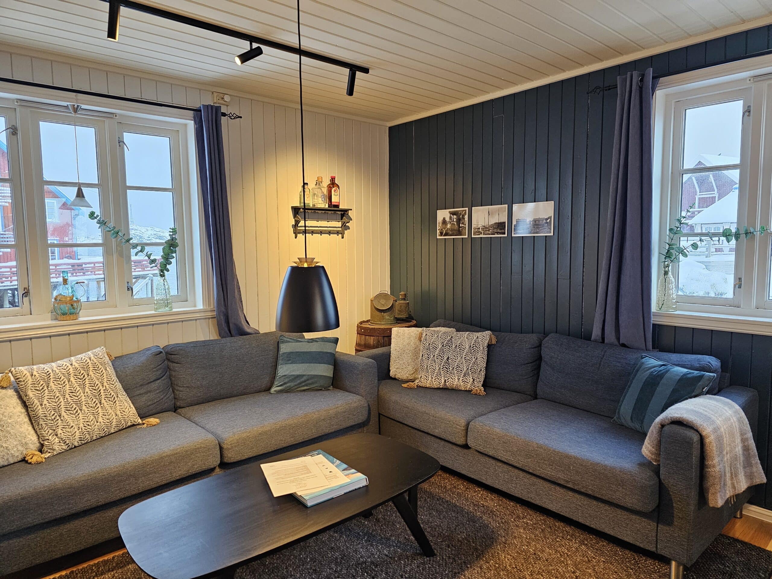 Sofakrok med store vinduer i rorbu på Å Rorbuer.