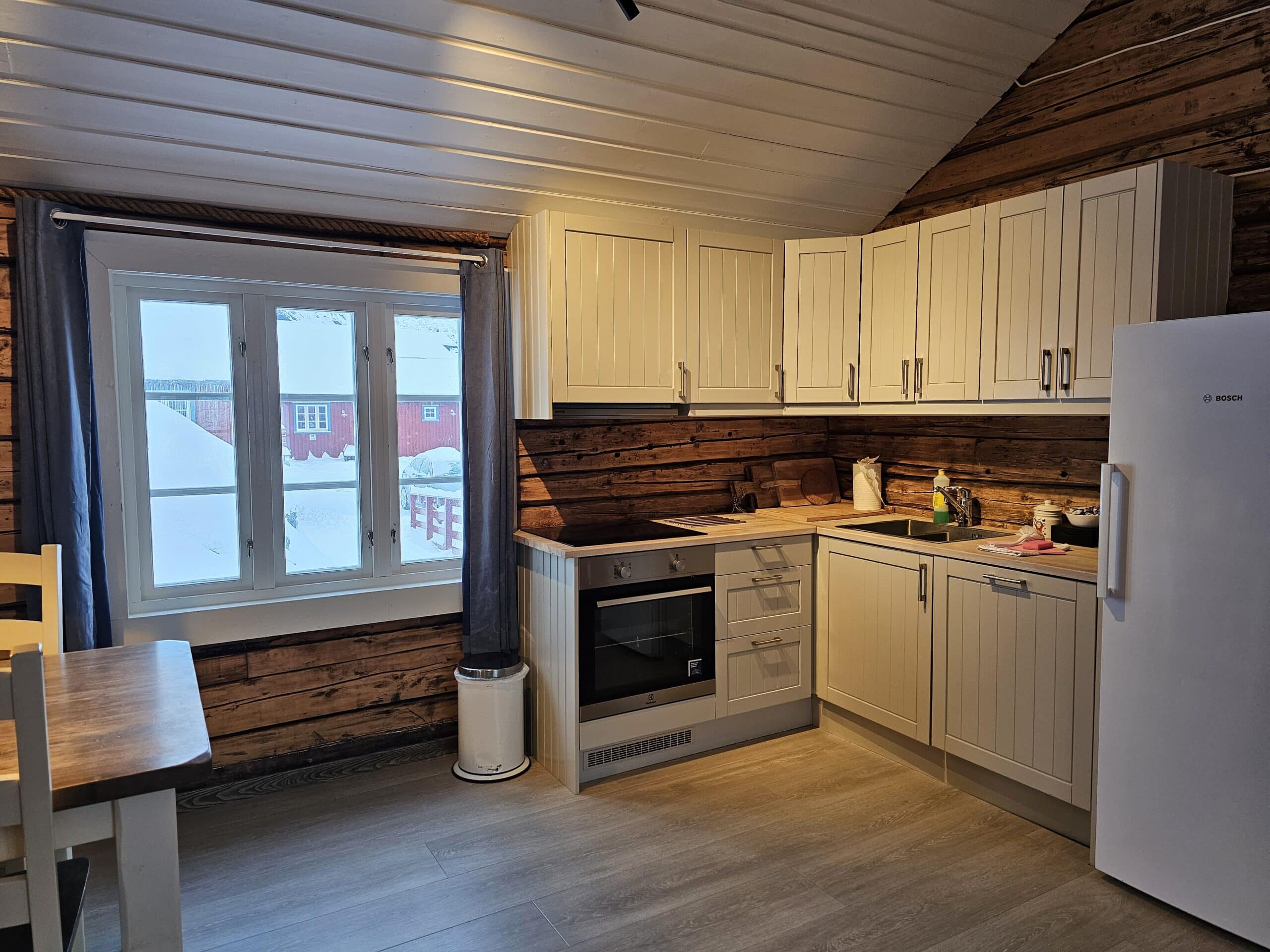 Moderne kjøkken med hvite fronter i rorbu på Å Rorbuer.